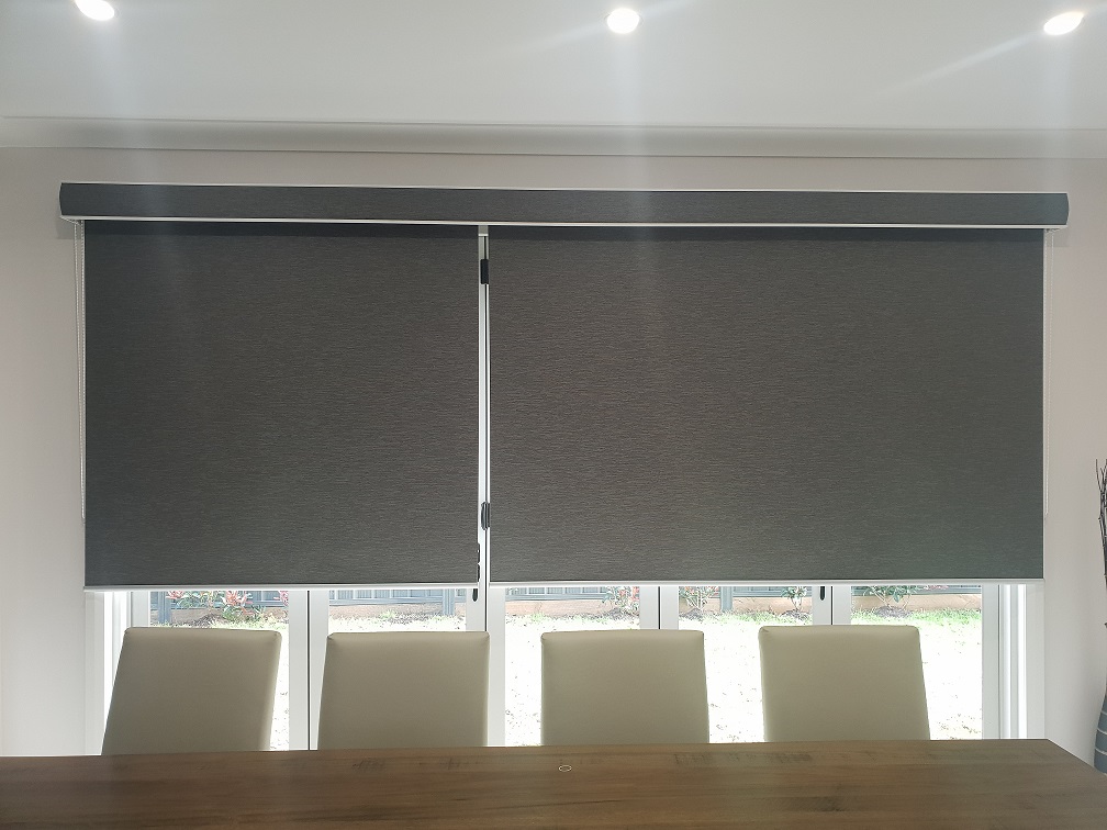Grey roller blinds with Multipelmet installed across a wide window by Apollo Blinds Wollongong