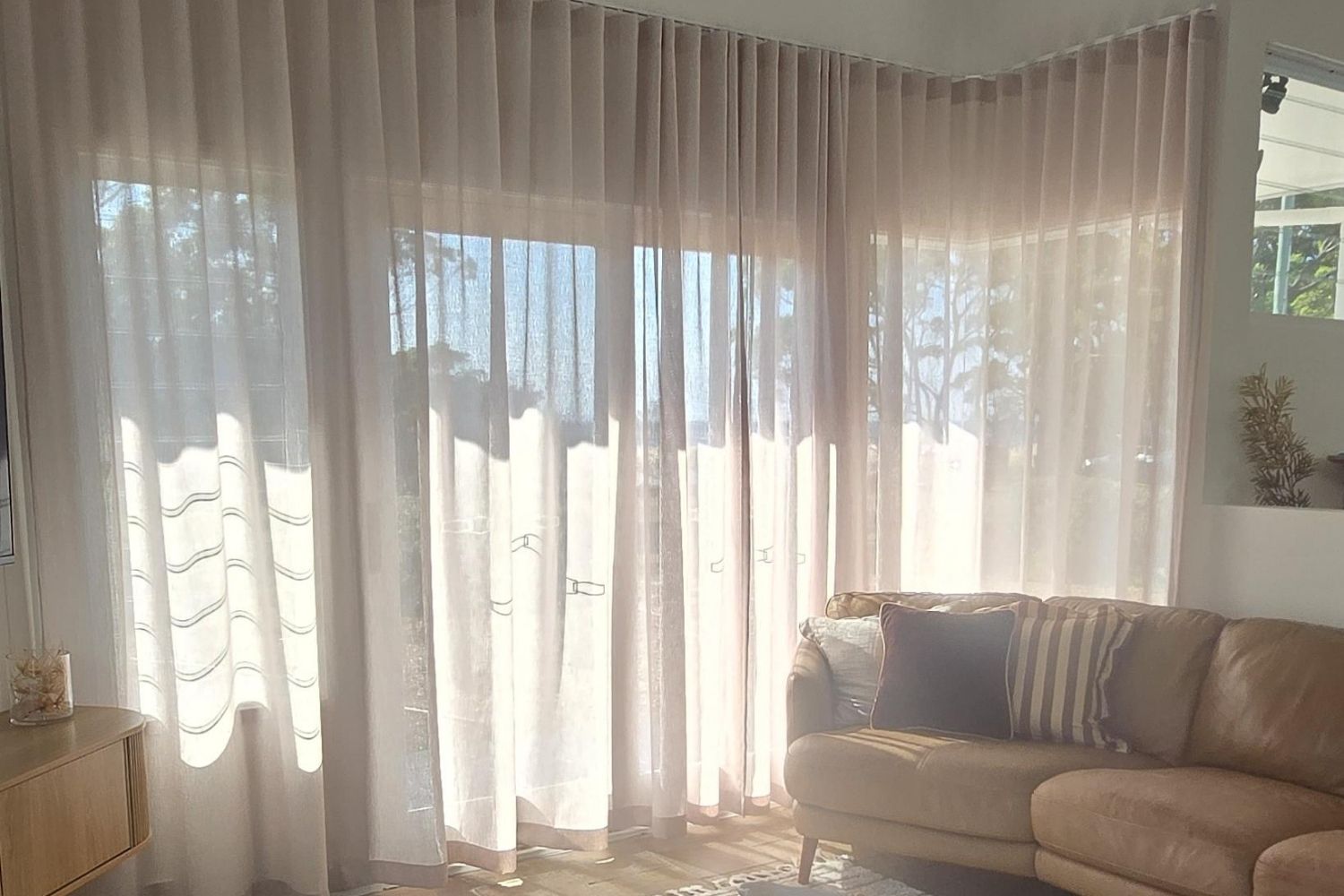 Full-height sheer curtains installed in a modern open-plan Wollongong living room by Apollo Blinds Wollongong.