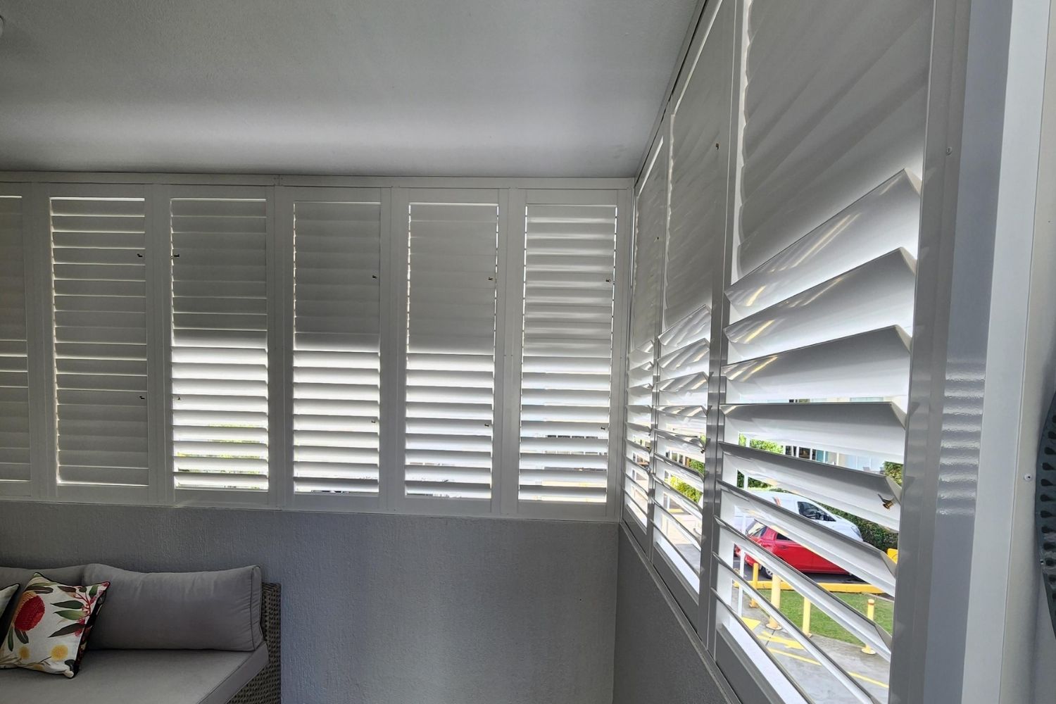 White PVC shutters installed on a tall interior window by Apollo Blinds Wollongong.