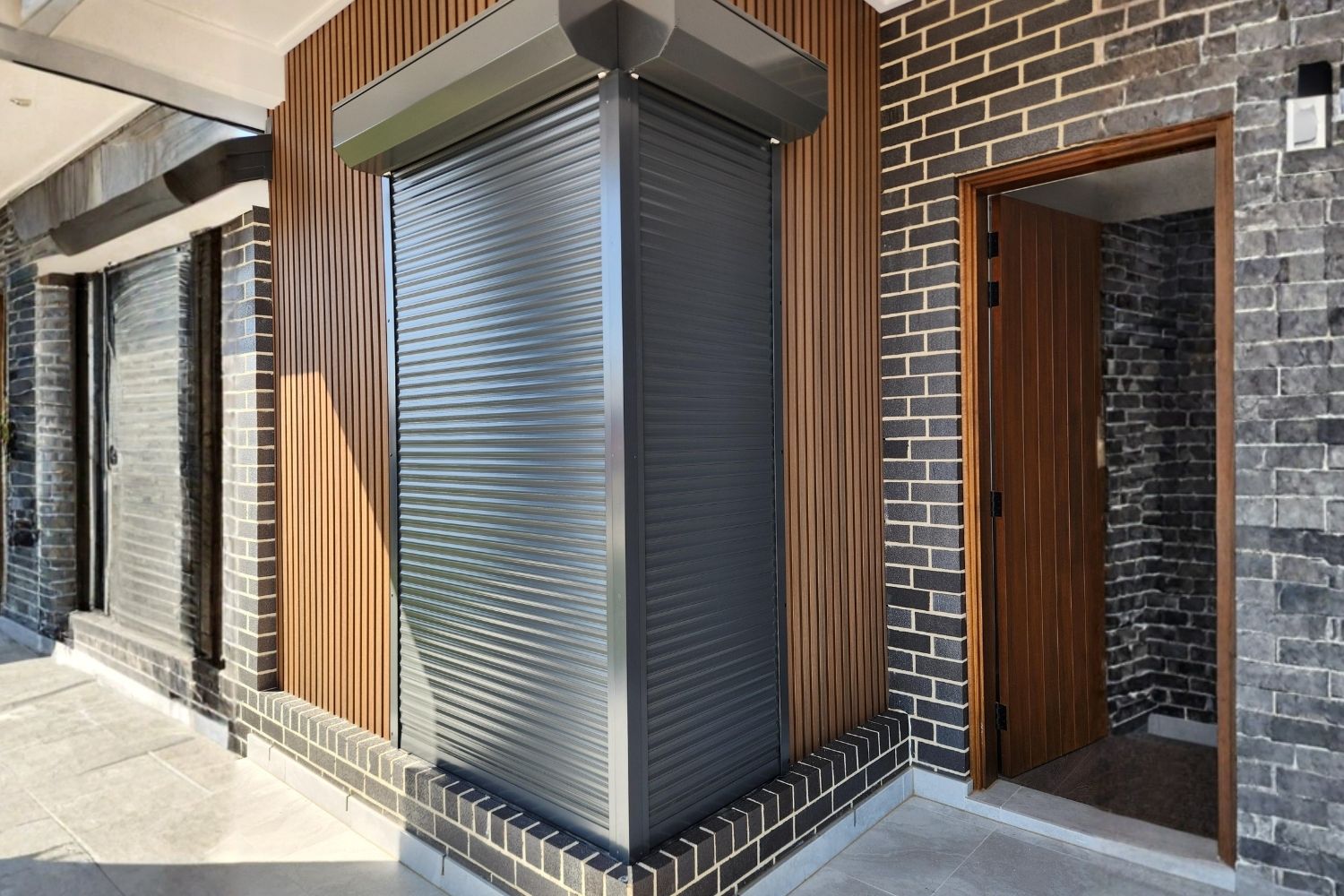 Black roller shutter installed on a modern Wollongong home exterior by Apollo Blinds Wollongong.