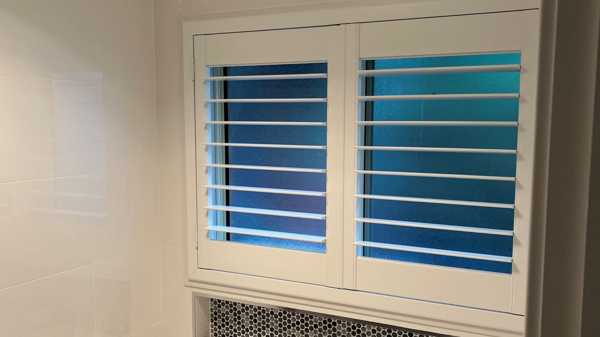 White Bathroom Shutters in a Tiled Bathroom