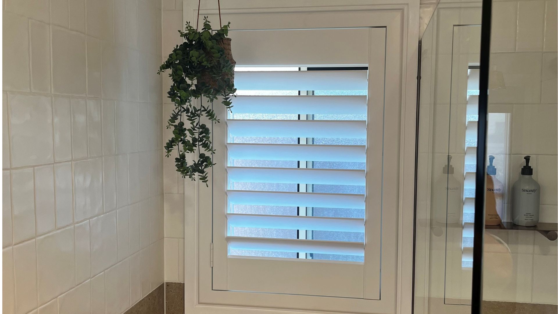 White Bathroom Shutters in a Classic Tiled Bathroom
