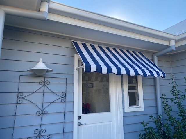 Blue and white striped fixed cafe awning installed above a side door by Apollo Blinds Tamworth.