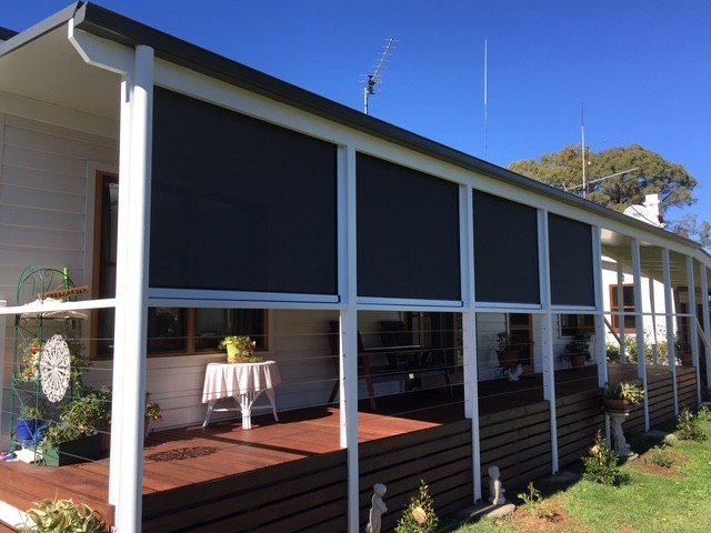 Dark outdoor blinds installed across a covered deck by Apollo Blinds Tamworth.